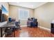 Well-lit home office with hardwood floors, multiple monitors, and functional workspace at 11938 S Meander Way, Parker, CO 80138