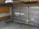 Depicts a garage with a partially damaged door and storage shelves at 3930 S Quatar St, Aurora, CO 80018