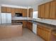 Well-lit kitchen featuring oak cabinets, an island, and modern appliances set in a functional layout at 3930 S Quatar St, Aurora, CO 80018