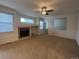 Inviting living room with a fireplace, neutral carpet, ceiling fan, and ample natural light, creating a warm atmosphere at 3930 S Quatar St, Aurora, CO 80018