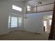 Bright living room featuring an open floor plan with neutral paint, large windows, and a view of the second-story railing at 3930 S Quatar St, Aurora, CO 80018