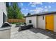 This outdoor patio has stylish seating around a fireplace, modern design elements, and a yellow door at 1195 S Milwaukee St, Denver, CO 80210