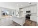 Modern kitchen with white cabinets, island, stainless steel appliances, and sliding glass doors at 9663 Ceylon St, Commerce City, CO 80022