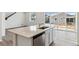 Kitchen island with white cabinets, quartz countertop, and stainless steel dishwasher at 9663 Ceylon St, Commerce City, CO 80022