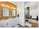 Modern bathroom with double vanity, walk-in shower, and wood-like tile at 3343 S Newcombe St, Lakewood, CO 80227