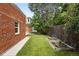 Landscaped backyard featuring a brick house, grassy area, and raised garden beds at 3330 W 30Th Ave, Denver, CO 80211