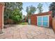 Stone patio and yard feature brick building with trees and blue door at 3330 W 30Th Ave, Denver, CO 80211