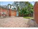 Spacious stone patio with brick house, trees, and a blue door entrance at 3330 W 30Th Ave, Denver, CO 80211
