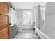 Charming bathroom with wood door, tile floor, window and classic tub at 3330 W 30Th Ave, Denver, CO 80211
