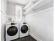 Modern laundry room with white washer and dryer, wainscoting and floating shelves at 3330 W 30Th Ave, Denver, CO 80211