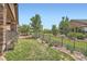 Landscaped backyard features an iron fence and green lawn at 15637 Deer Mountain Cir, Broomfield, CO 80023