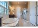Bright bathroom displays large tub, tile floors, and separate glass enclosed shower at 15637 Deer Mountain Cir, Broomfield, CO 80023