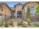Close up of a home entrance with stone accents, arched entryway, and vibrant landscaping leading to the front door at 15637 Deer Mountain Cir, Broomfield, CO 80023