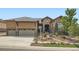Inviting home with a stone and stucco exterior, lush front yard landscaping, and a spacious three-car garage at 15637 Deer Mountain Cir, Broomfield, CO 80023