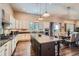 Open kitchen with white cabinetry, stainless appliances, and a large island flowing into dining area at 15637 Deer Mountain Cir, Broomfield, CO 80023