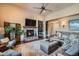 Inviting living room featuring a stone fireplace, hardwood floors, and neutral decor with a view into the foyer at 15637 Deer Mountain Cir, Broomfield, CO 80023