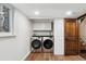 Well-lit basement laundry room, featuring modern washer and dryer, and ample storage at 11921 W 70Th Pl, Arvada, CO 80004