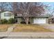 Brick ranch home with a spacious yard, attached garage, and mature tree at 11921 W 70Th Pl, Arvada, CO 80004