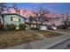 Ranch style home with green exterior, attached garage, and landscaping at 11921 W 70Th Pl, Arvada, CO 80004