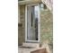 White front door with storm door and brick exterior at 11921 W 70Th Pl, Arvada, CO 80004