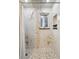 Large shower with marble walls and pebble floor at 11921 W 70Th Pl, Arvada, CO 80004
