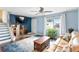 Bright living room with a large window, TV, blue accent wall and stairs to the second floor at 10405 W 107Th Pl, Broomfield, CO 80021