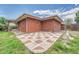 View of the rear exterior of the home with a small patio that has alternating brick and concrete tiles at 3463 W Bowles Ave, Littleton, CO 80123