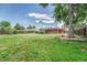 Large backyard features a massive tree, open grass area, full perimeter fence, and red brick home at 3463 W Bowles Ave, Littleton, CO 80123