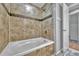 Modern bathroom with tiled tub, updated fixtures, and a neutral color palette at 3463 W Bowles Ave, Littleton, CO 80123