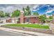 Brick home with a green lawn, mature trees, and a charming brick retaining wall at 3463 W Bowles Ave, Littleton, CO 80123