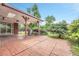 Outdoor patio with brick flooring, open backyard featuring lots of greenery, and an overhead cover supported by wood beams at 3463 W Bowles Ave, Littleton, CO 80123