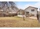 Backyard featuring a small patio, enclosed sunroom, and partial fencing at 10450 W 81St Pl, Arvada, CO 80005