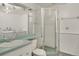 Bathroom featuring a glass enclosed shower, basin sink, and a view into the laundry room at 10450 W 81St Pl, Arvada, CO 80005