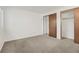 Bright bedroom featuring neutral carpet, white walls, and large closet with sliding doors at 10450 W 81St Pl, Arvada, CO 80005