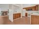 Bright kitchen with classic wood cabinetry, white appliances, and an adjacent living space at 10450 W 81St Pl, Arvada, CO 80005