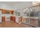 Well-lit kitchen with wood cabinets, white appliances, and access to a sunroom at 10450 W 81St Pl, Arvada, CO 80005