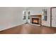 Living room features a brick fireplace, bright windows, and warm-toned laminate flooring at 10450 W 81St Pl, Arvada, CO 80005