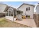 Screened in back porch with concrete patio, wood stairs and view of the fenced backyard at 10450 W 81St Pl, Arvada, CO 80005