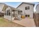 A sunroom featuring lots of windows is attached to this house with gray siding and a concrete patio at 10450 W 81St Pl, Arvada, CO 80005