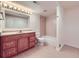 Bathroom with a wood vanity, tile floor, and a shower-tub combo at 6885 Saddleback Ave, Firestone, CO 80504