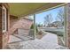 Cozy front porch featuring stone floor, brick walls and a decorative white railing at 6885 Saddleback Ave, Firestone, CO 80504