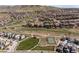 Expansive aerial view of residential community with green spaces, parks, and walking paths nestled in a mountainous setting at 2264 S Joyce St, Lakewood, CO 80228