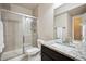 Bathroom with glass enclosed shower, granite countertops, and dark wood cabinets at 2264 S Joyce St, Lakewood, CO 80228