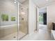 Bright bathroom featuring glass shower, soaking tub, and neutral-colored tiles at 2264 S Joyce St, Lakewood, CO 80228