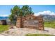 Stone sign for Forsberg Iron Spring Park, with lush greenery and mountain views in the background at 2264 S Joyce St, Lakewood, CO 80228