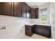 Well-lit laundry room with dark cabinets, a sink, and washer/dryer hookups for convenient chores at 2264 S Joyce St, Lakewood, CO 80228