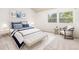 Bright bedroom with a large window providing ample natural light, features stylish blue and white decor and a cozy sitting area at 9917 Garland Dr, Broomfield, CO 80021
