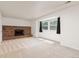 Bright living room with large brick fireplace, light carpet, and large window at 9917 Garland Dr, Broomfield, CO 80021