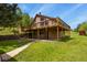 This home features a large deck, stone accent wall, and a well-maintained lawn at 30221 Stagecoach Blvd, Evergreen, CO 80439