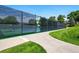 A fenced community tennis court with new surfacing is surrounded by manicured green lawns and mature trees at 6979 E Fremont Ave, Centennial, CO 80112